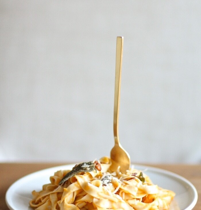 butternut squash pasta on white plate with fork sticking up