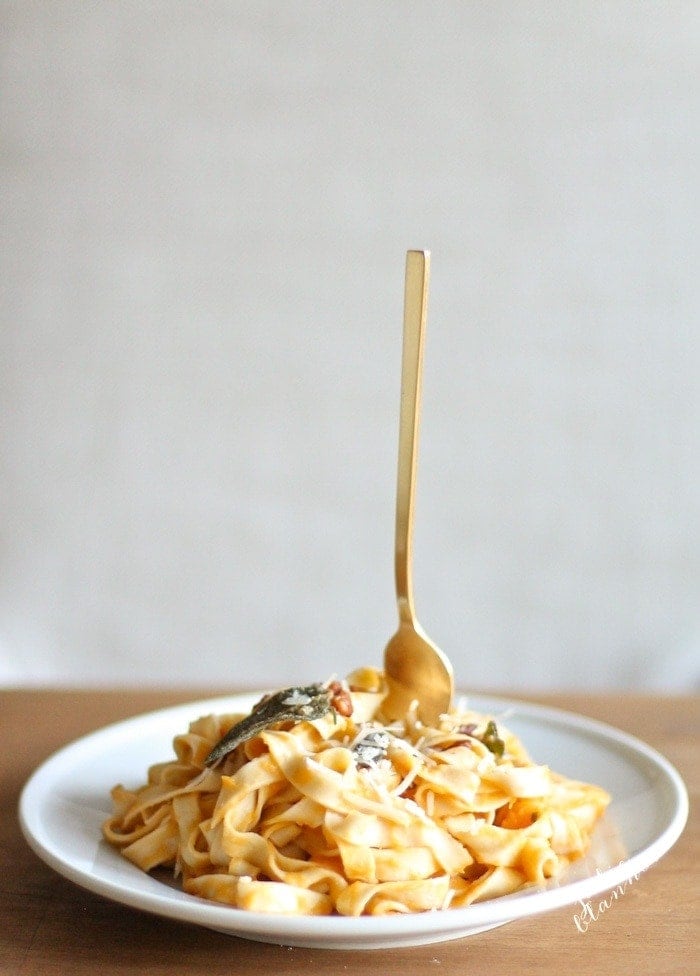 butternut squash pasta on white plate with fork sticking up