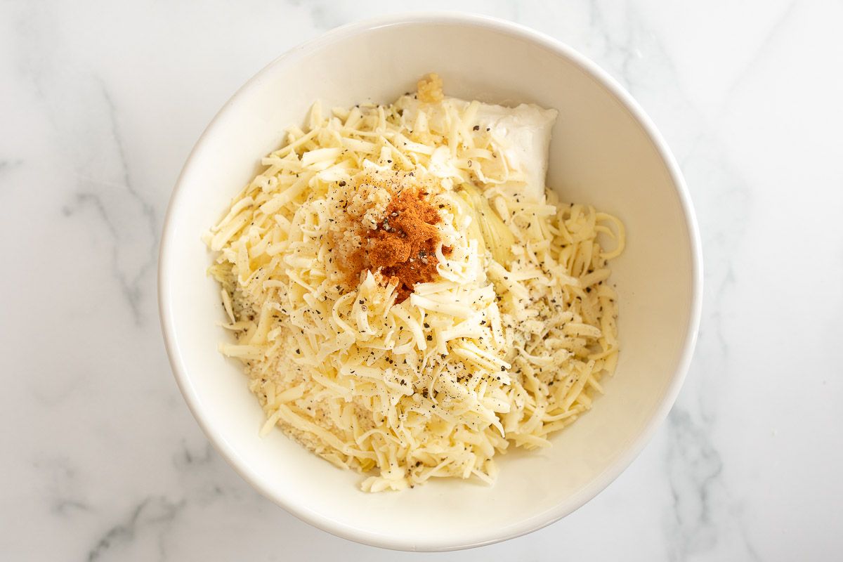 A white bowl full of a artichoke dip recipe