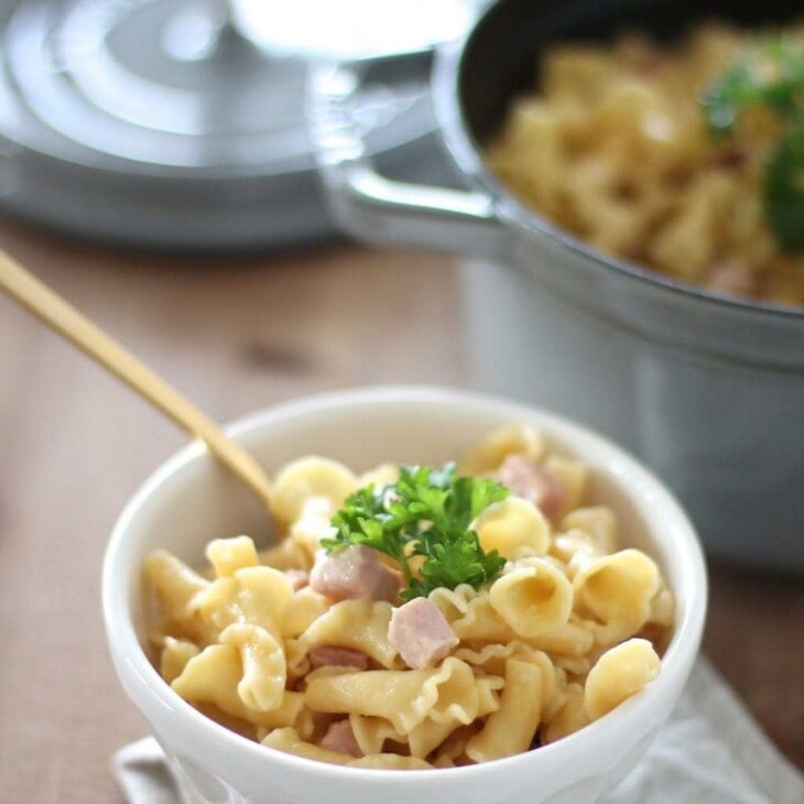 truffle mac and cheese in a white bowl with gold spoon