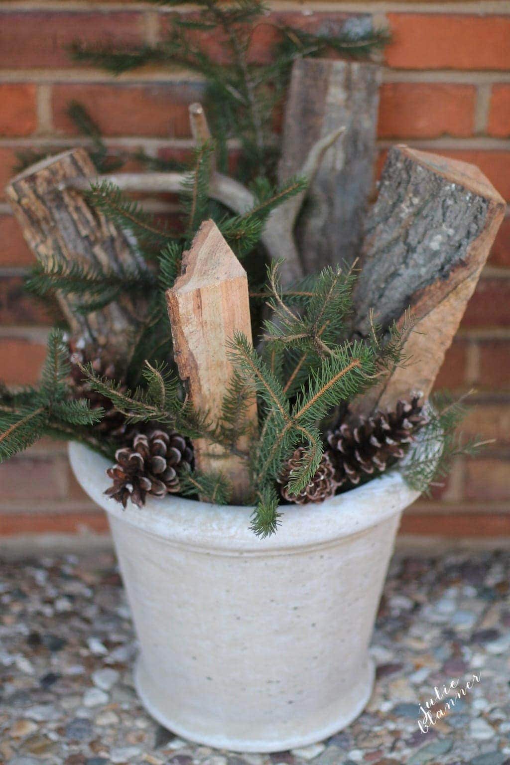 fall flower arrangement in pot with antlers wood pinecone and branches