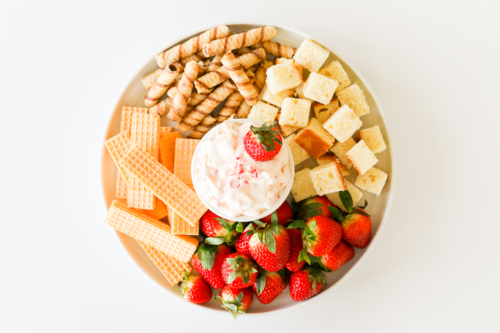 A plate with strawberries and a sweet dip.