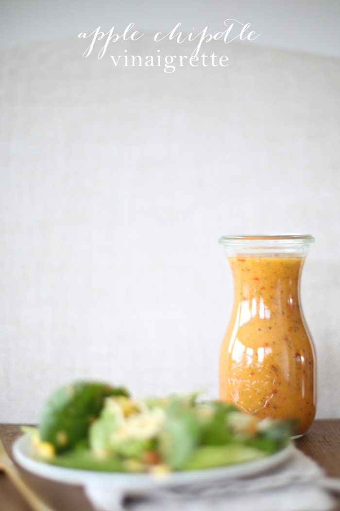 apple chipotle vinaigrette recipe in glass bottle with salad on white plate with text overlay