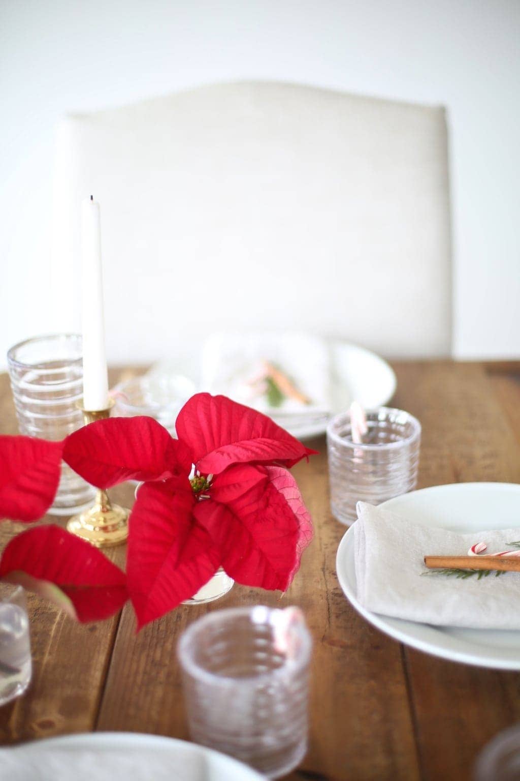 A red Poinsettia centerpiece cut into vases down the center of a table