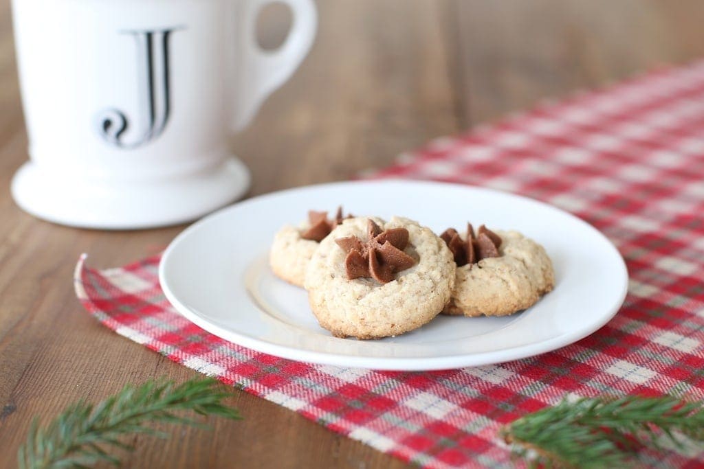 Three chocolate iced pecan thumbprint cookies ready to eat