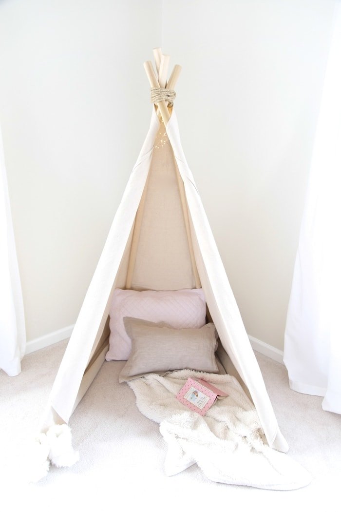 A teepee that is put together with pillows and blankets inside