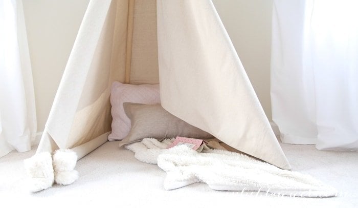 A teepee that is put together with pillows and blankets inside