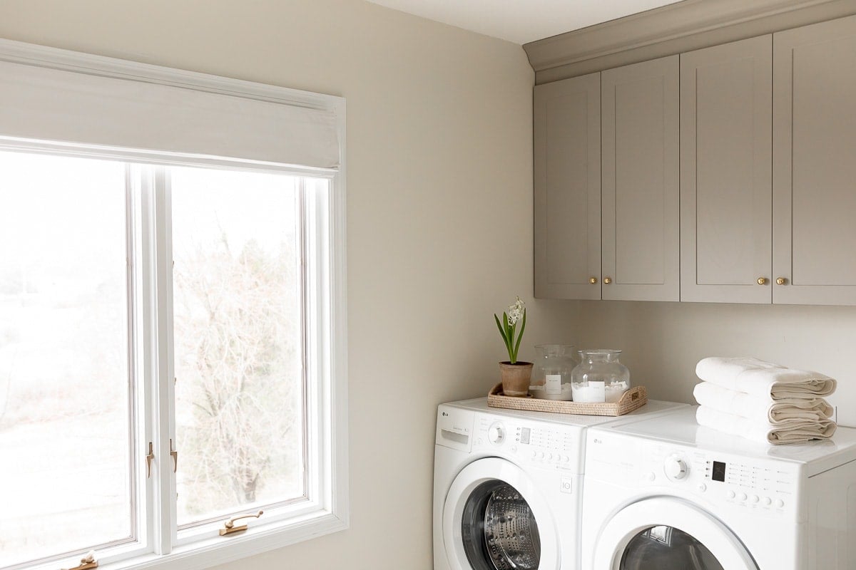 A laundry room with griege overlay cabinets