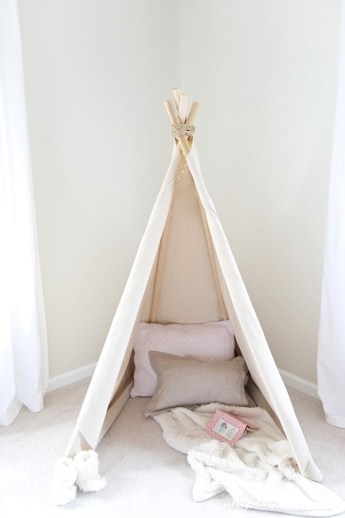 A teepee that is put together with pillows and blankets inside