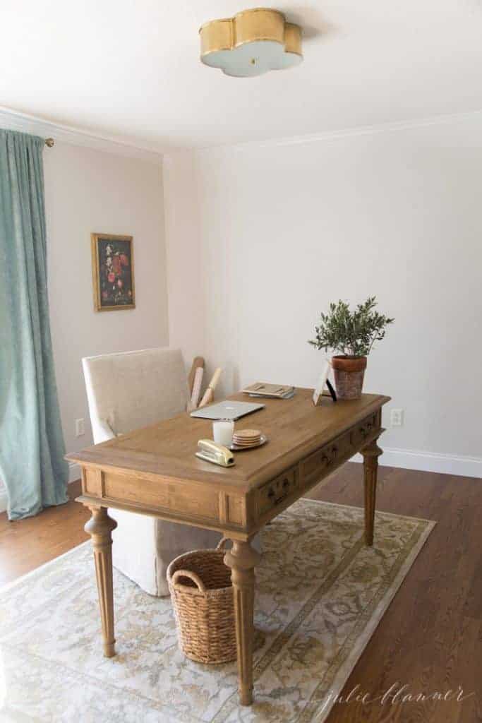 An office with a formal wooden desk and a brass ceiling light.