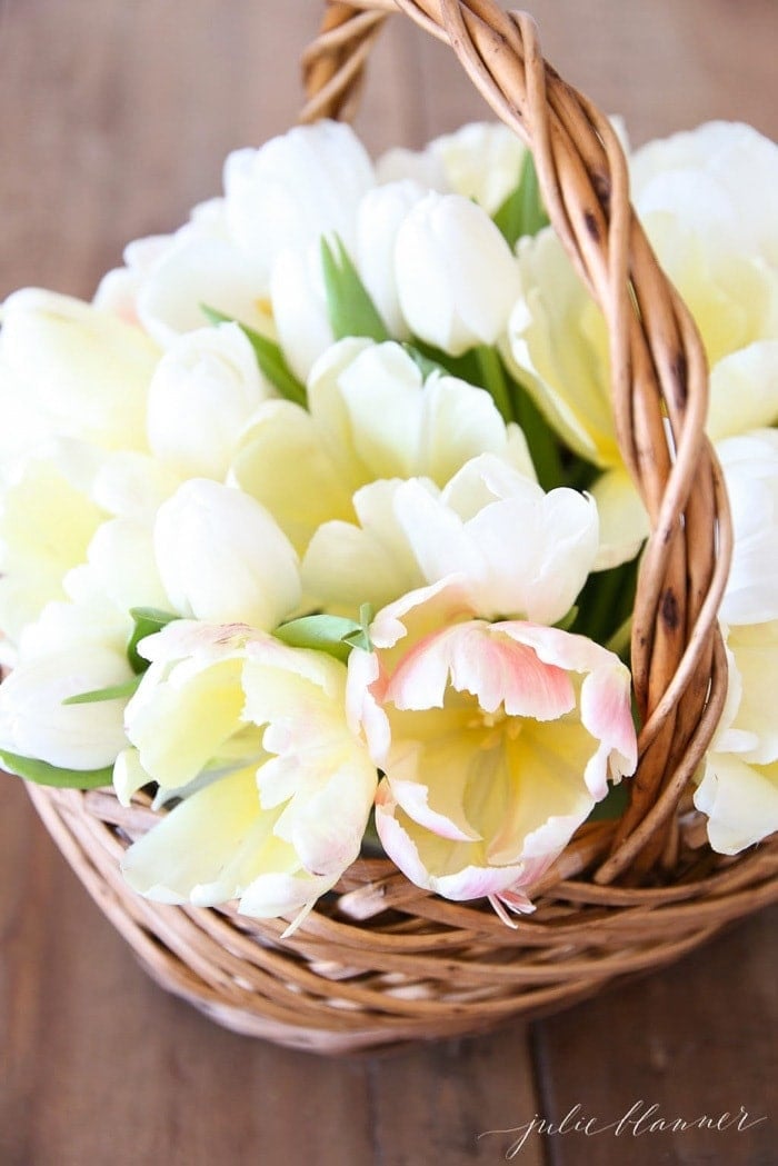 A wicker basket filled with pale yellow tulips.