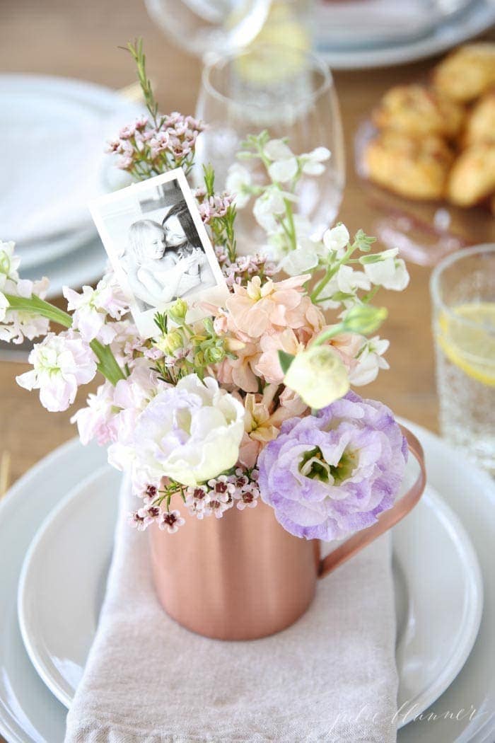 Beautiful Mother's Day decor table setting idea with diy flower arrangements on a napkin folded across a plate.