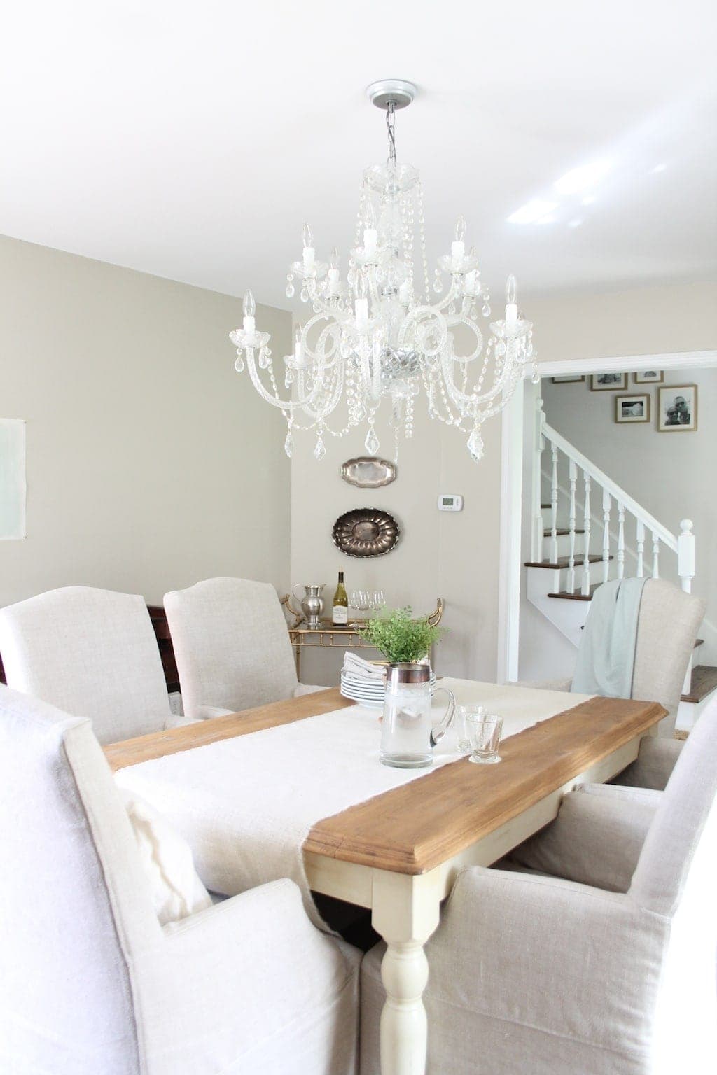 Luxury Home decor in a soft neutral dining room with a farm table and linen chairs.