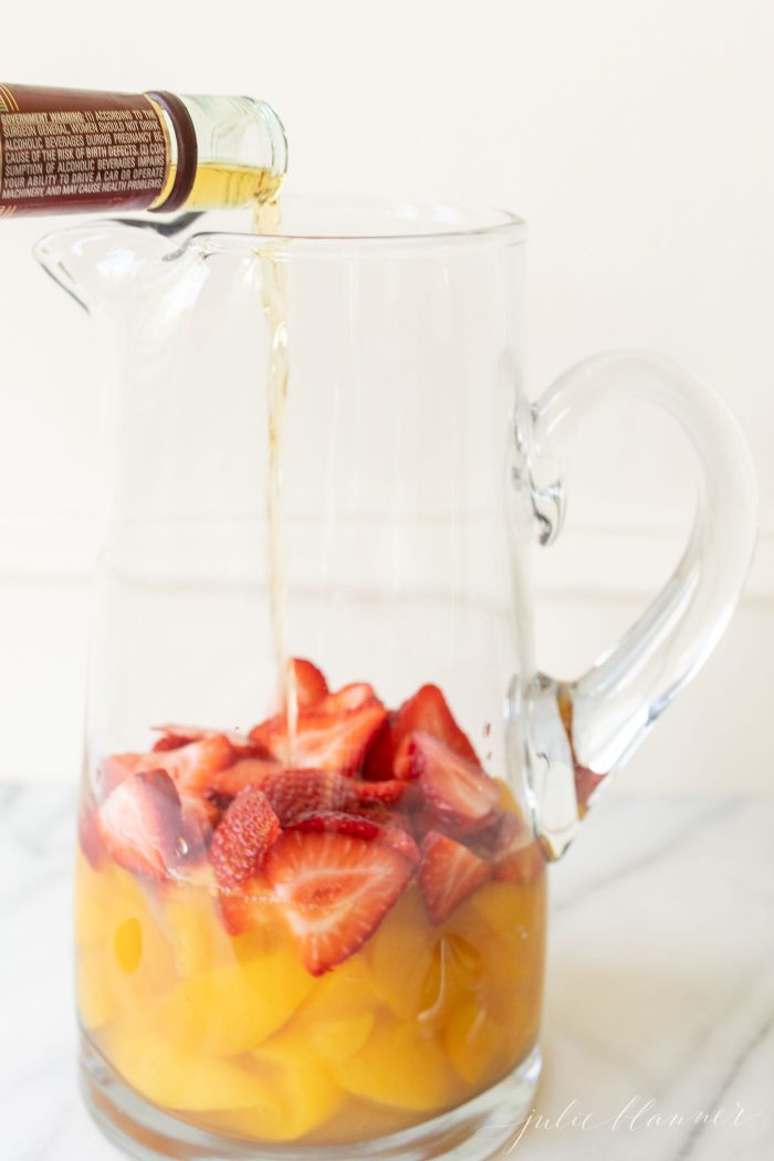 using brandy for sangria pouring in a pitcher