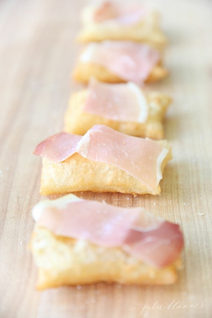 gnocco frito topped with olive oil, prosciutto, and sea salt