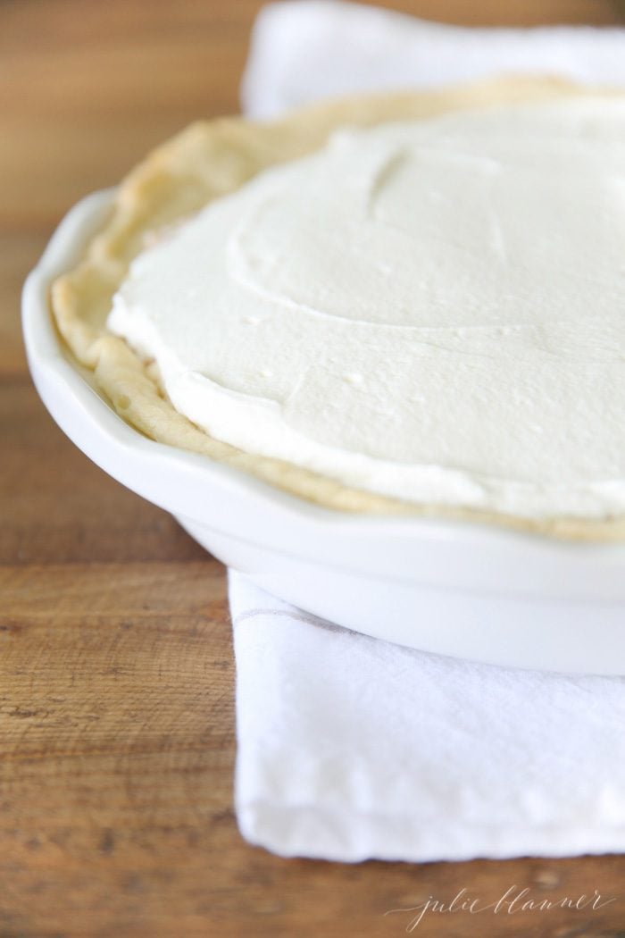 homemade banana cream pie recipe in white pie dish on white towel