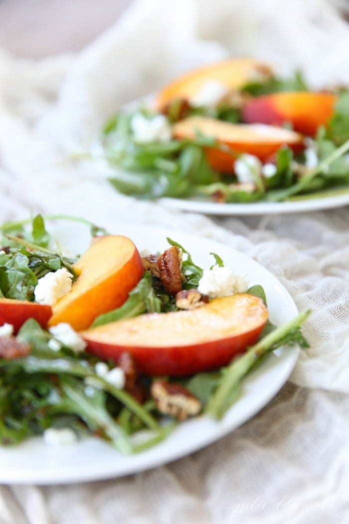 Sliced peaches on a bed of arugula