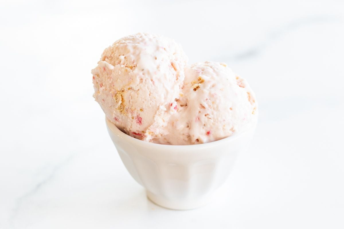 Strawberry cheesecake ice cream in a white bowl.