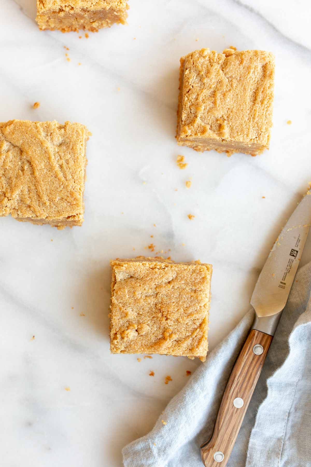 Peanut butter brownies cut into squares and spread out on a marble surface