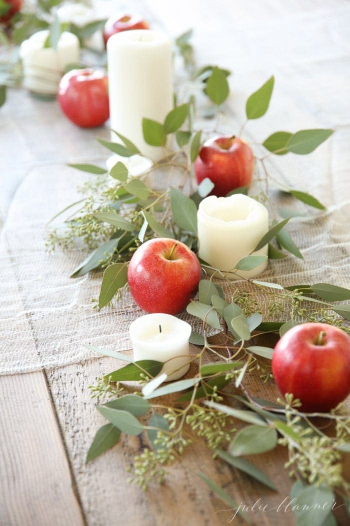 apple centerpiece down the middle of a wood table