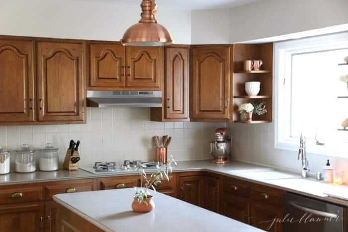 A modern kitchen with oak cabinets and warm copper accents