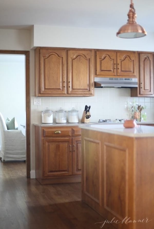 A kitchen with wood cabinets and hardwood floors that harmoniously complements the oak cabinets.