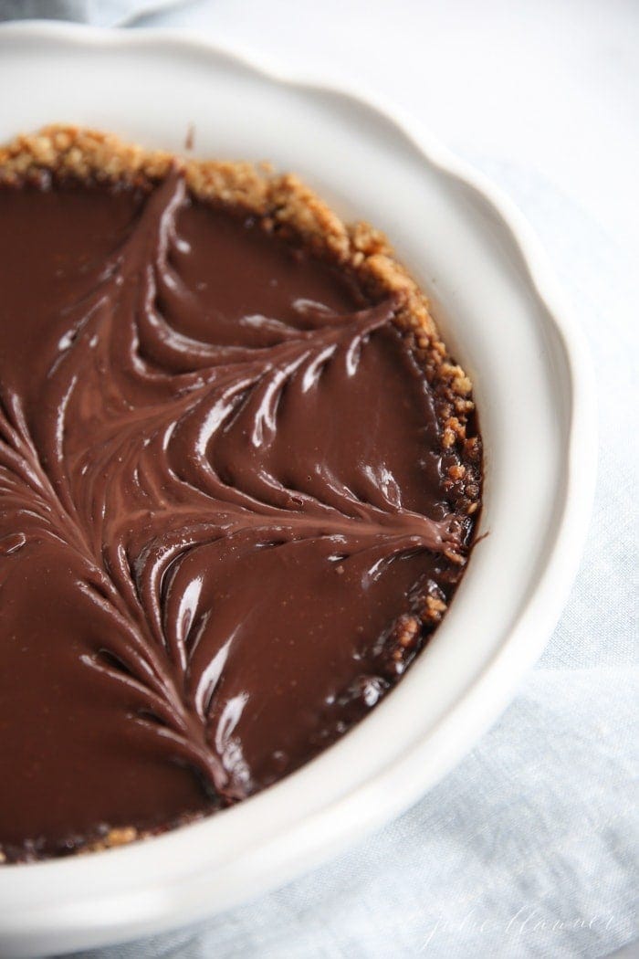 pretzel crust pie with chocolate filling in white baking dish