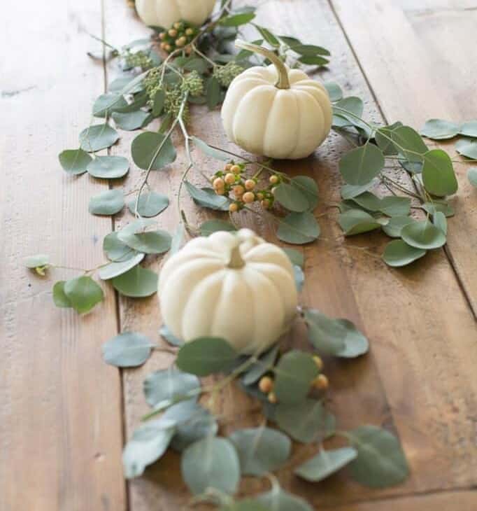 pumpkins and greenery on wood table