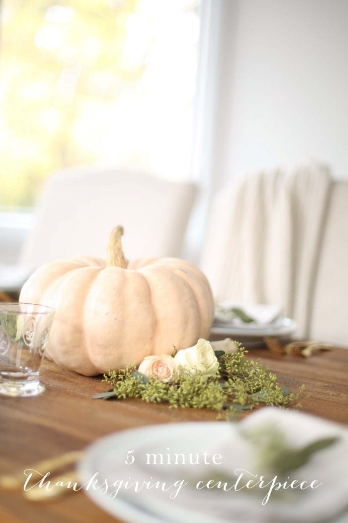 A Thanksgiving centerpiece set with a white pumpkin and fresh flowers below. 