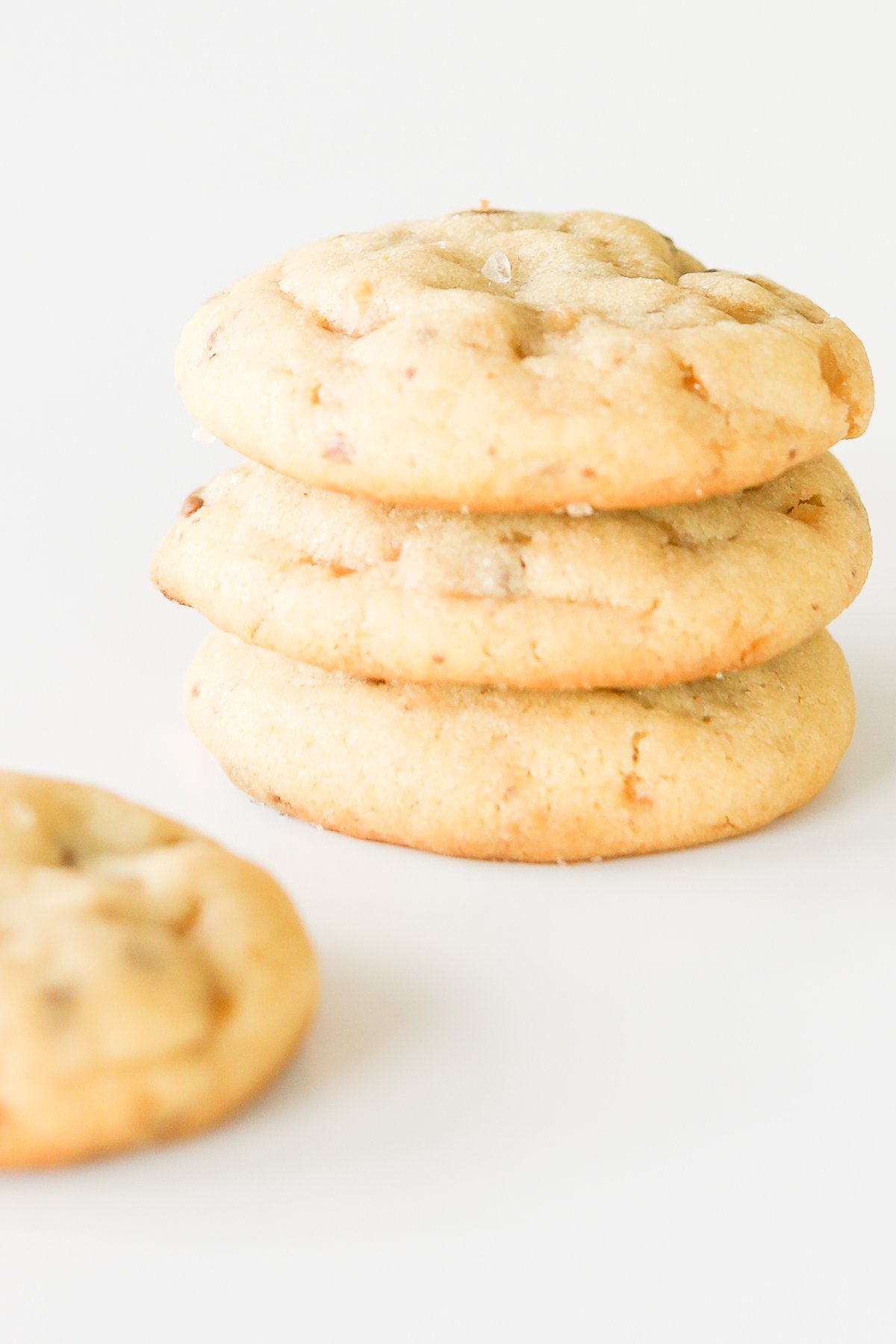 A stack of toffee cookies on a white surface.