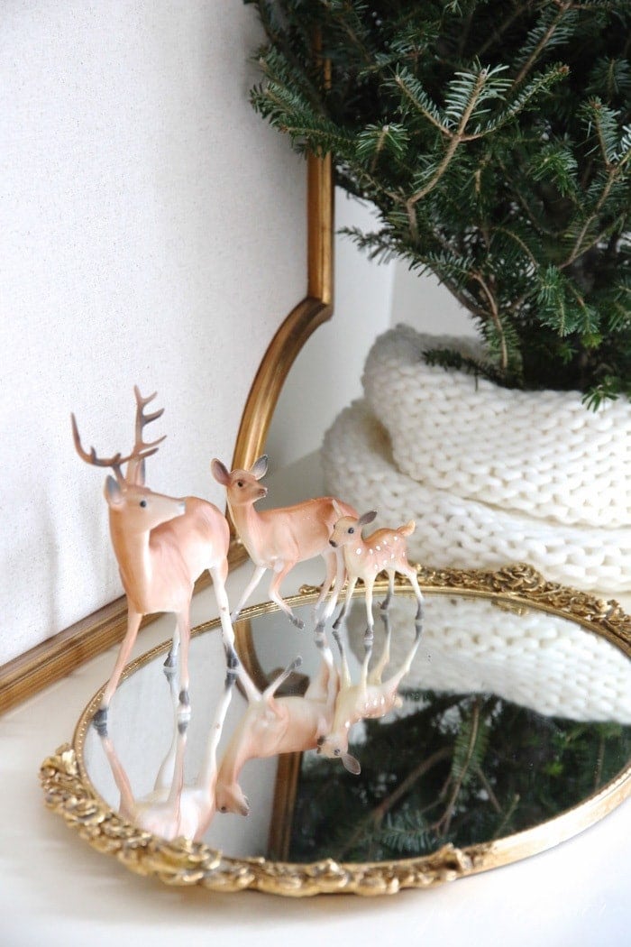 Small vintage ceramic deer on a gold mirrored dresser tray for a winter decor touch.