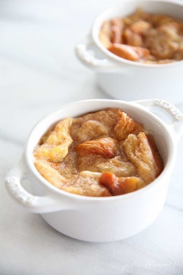 custard bread pudding in two white individual baking dishes