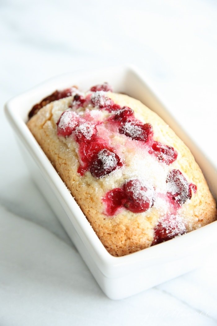 homemade cranberry bread in a white ceramic loaf pan