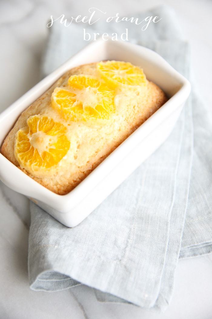 Sweet orange bread in a white baking dish with text overlay