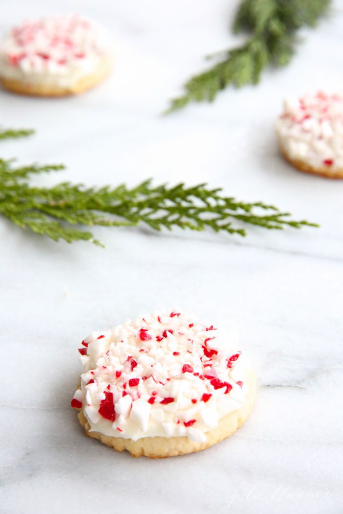 peppermint cookies on marble countertop with holly leaves