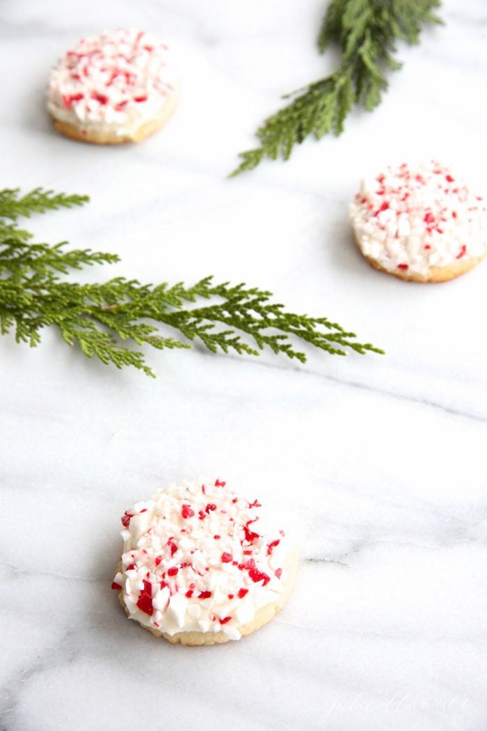 peppermint cookies on marble countertop with holly leaves