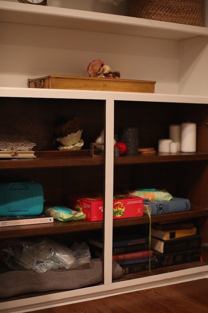 Built in cabinets filled with clutter in the before image of a makeover.