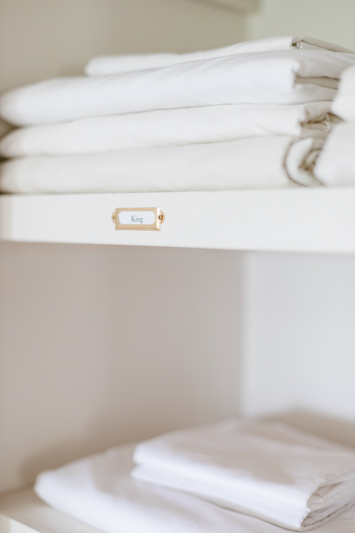 White sheets neatly stored in a linen closet.