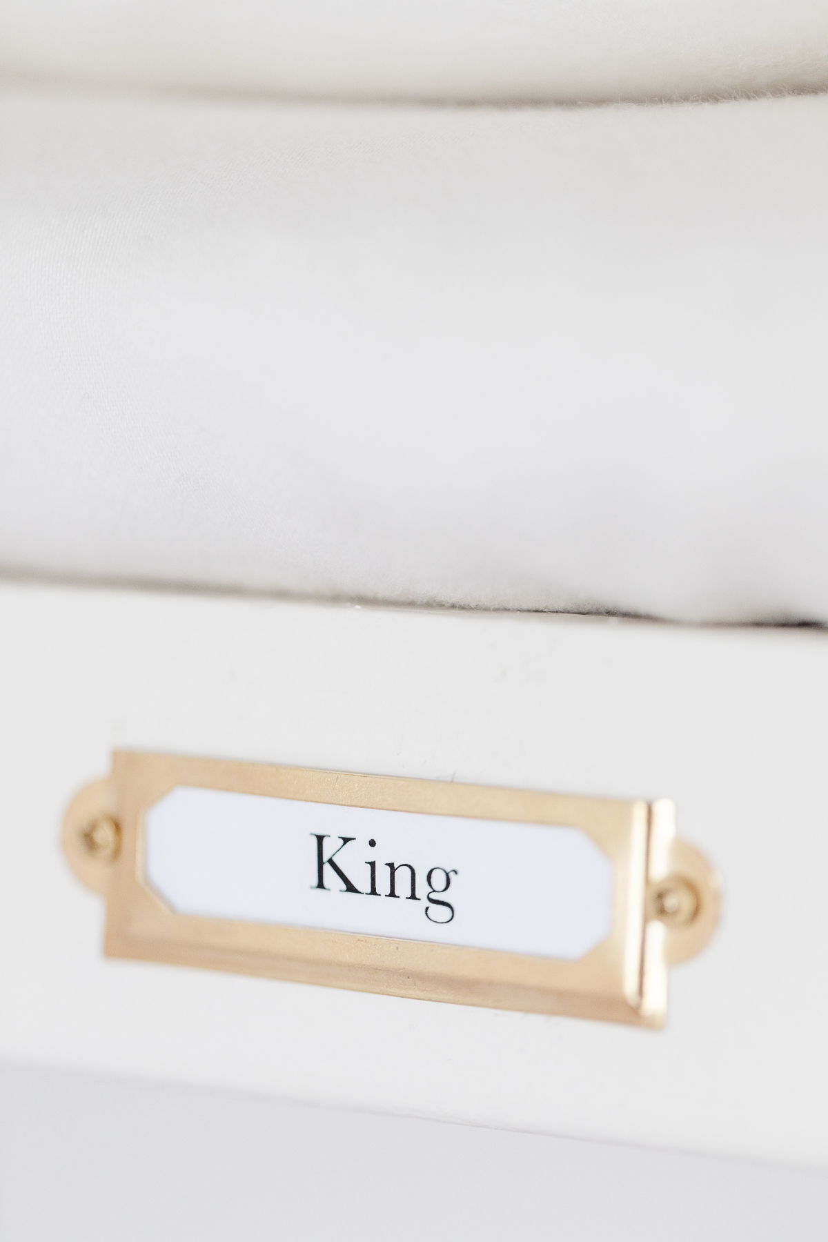 A white dresser with the word king on it, perfect for a linen closet.