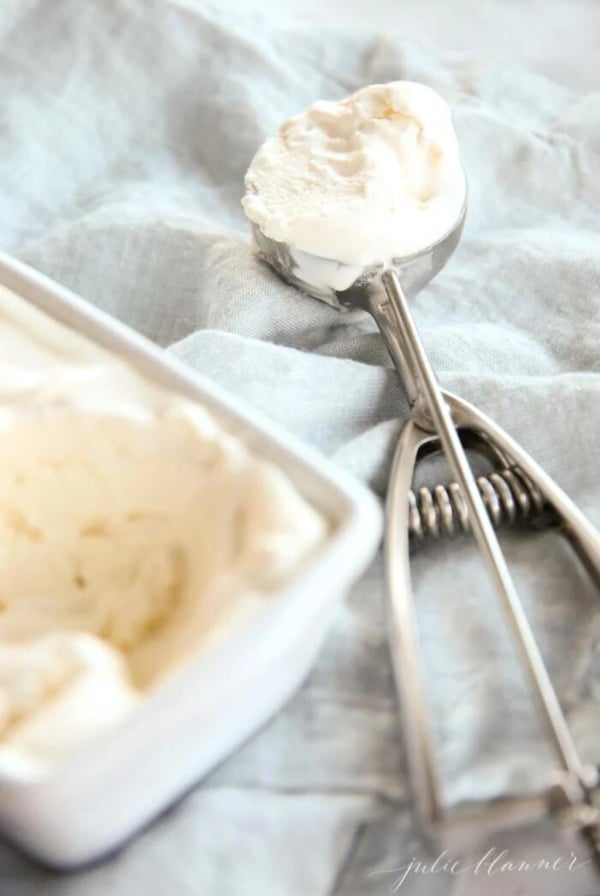 A bowl of homemade vanilla ice cream with a spoon next to it.