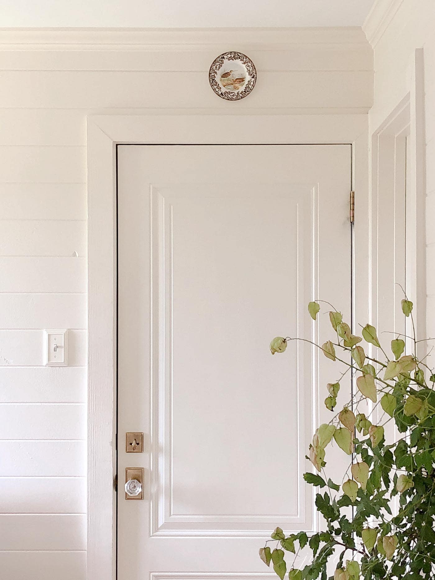 A mudroom with horizontal cream painted wood paneling.