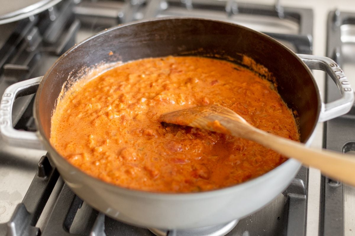 Vodka sauce simmering in a gray pot on a stove.