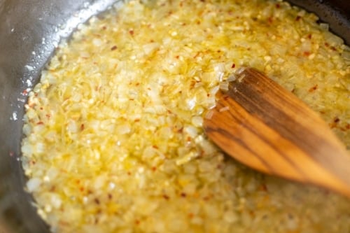 Onions and garlic cooking on a stovetop.