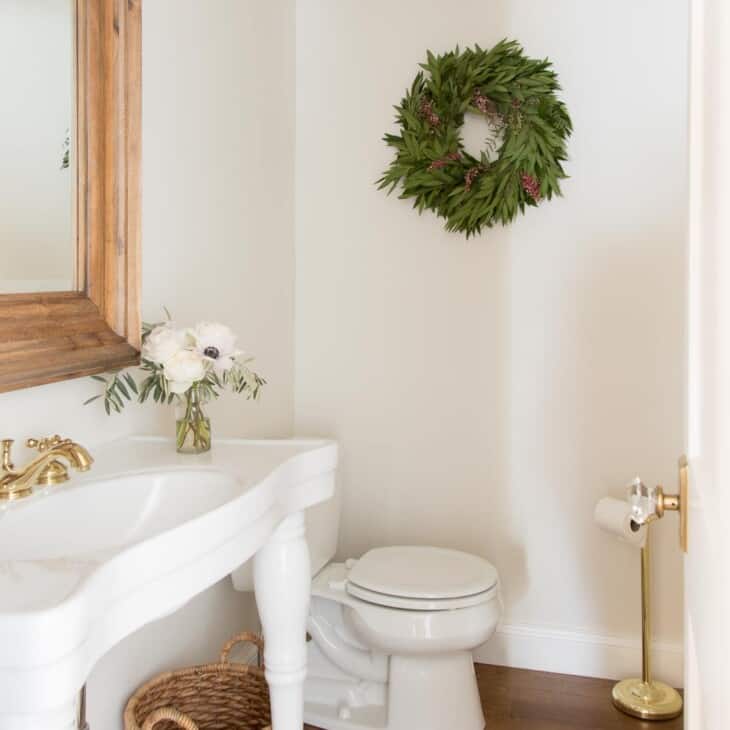 bathroom decorated for christmas with woven wastebasket parisian sink and turkish rug