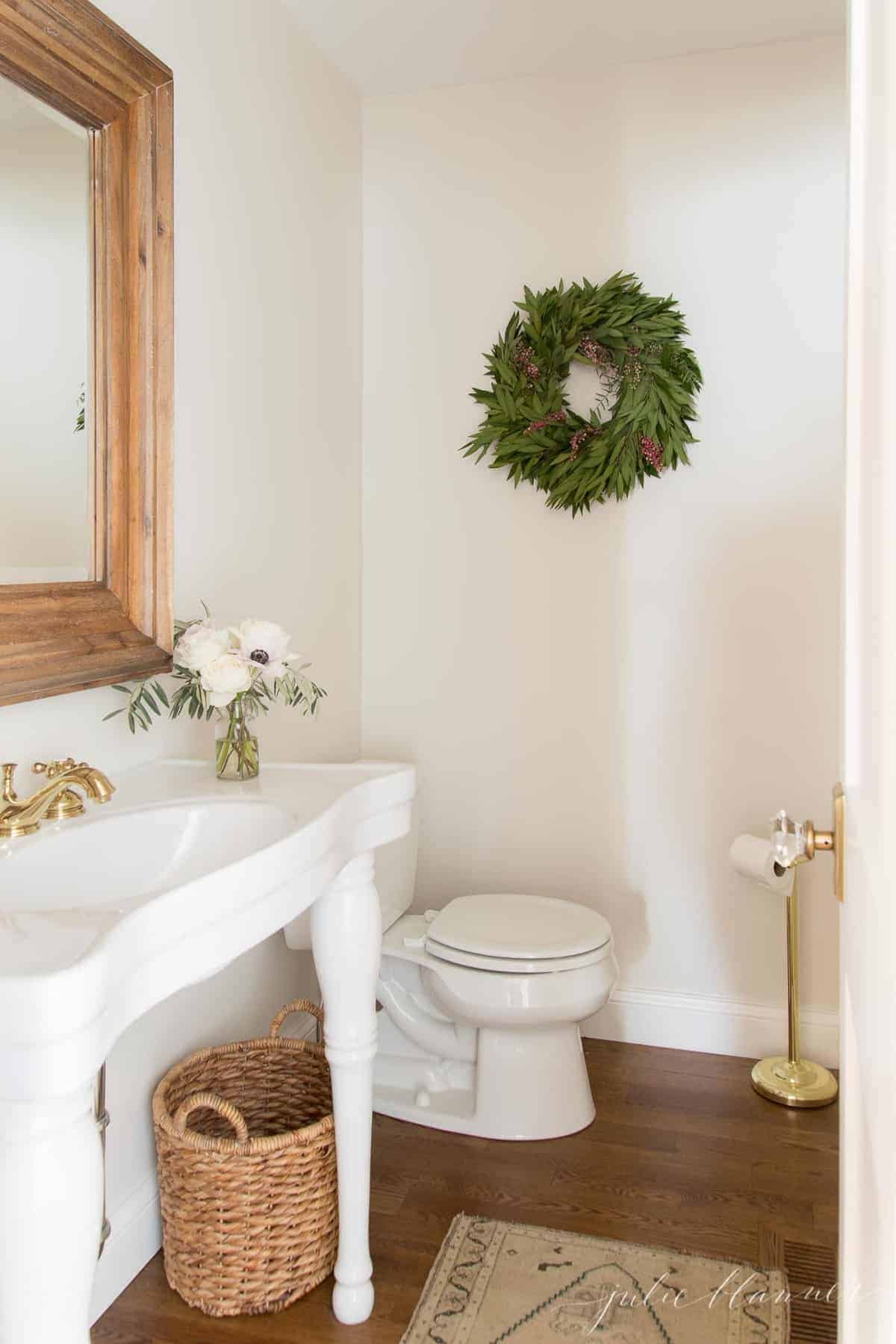 bathroom decorated for christmas with woven wastebasket parisian sink and turkish rug