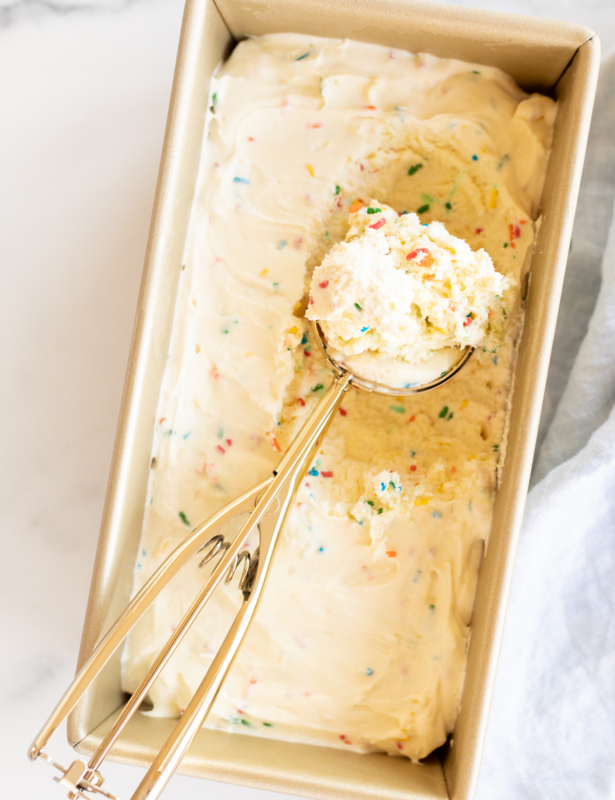 Homemade cake batter ice cream with rainbow sprinkles in a gold loaf pan.