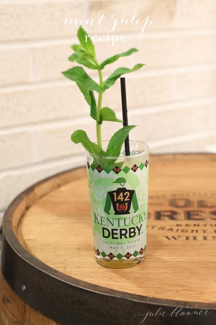 A mint julep garnished with fresh mint in a Kentucky Derby glass