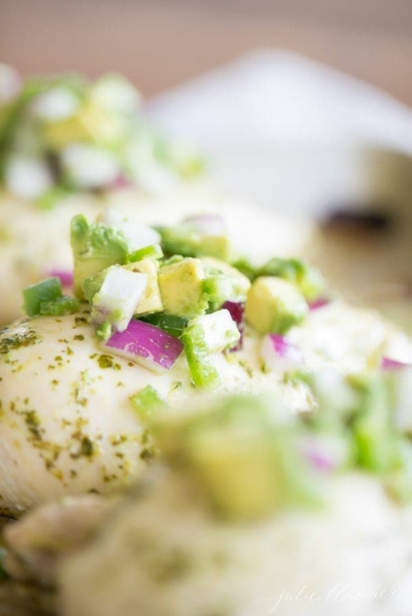 chunky pico de gallo with avocado on baked chicken breasts