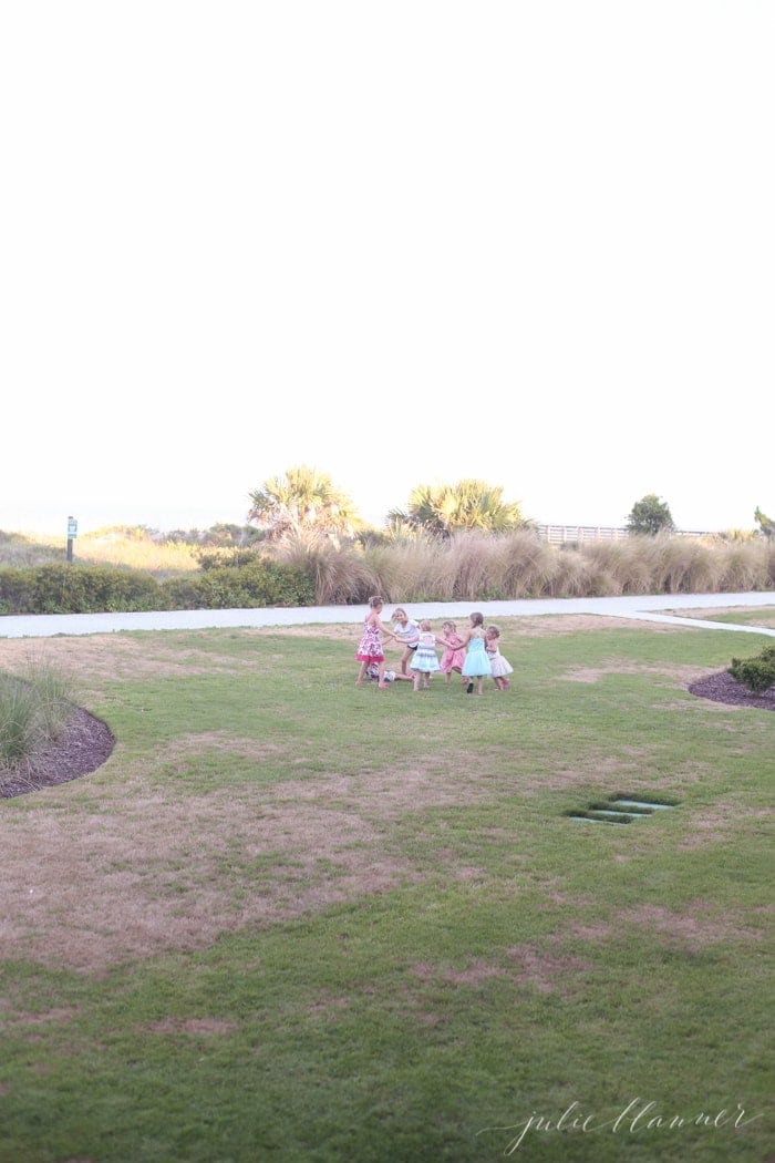Little girls in dresses holding hands in a circle