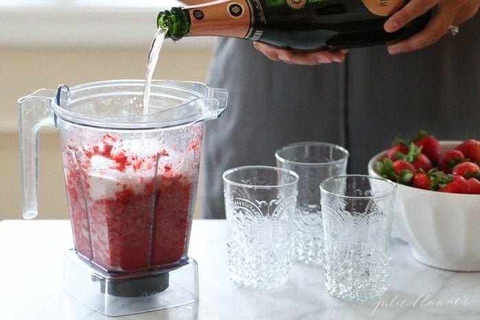 Pouring champagne into the frozen strawberries